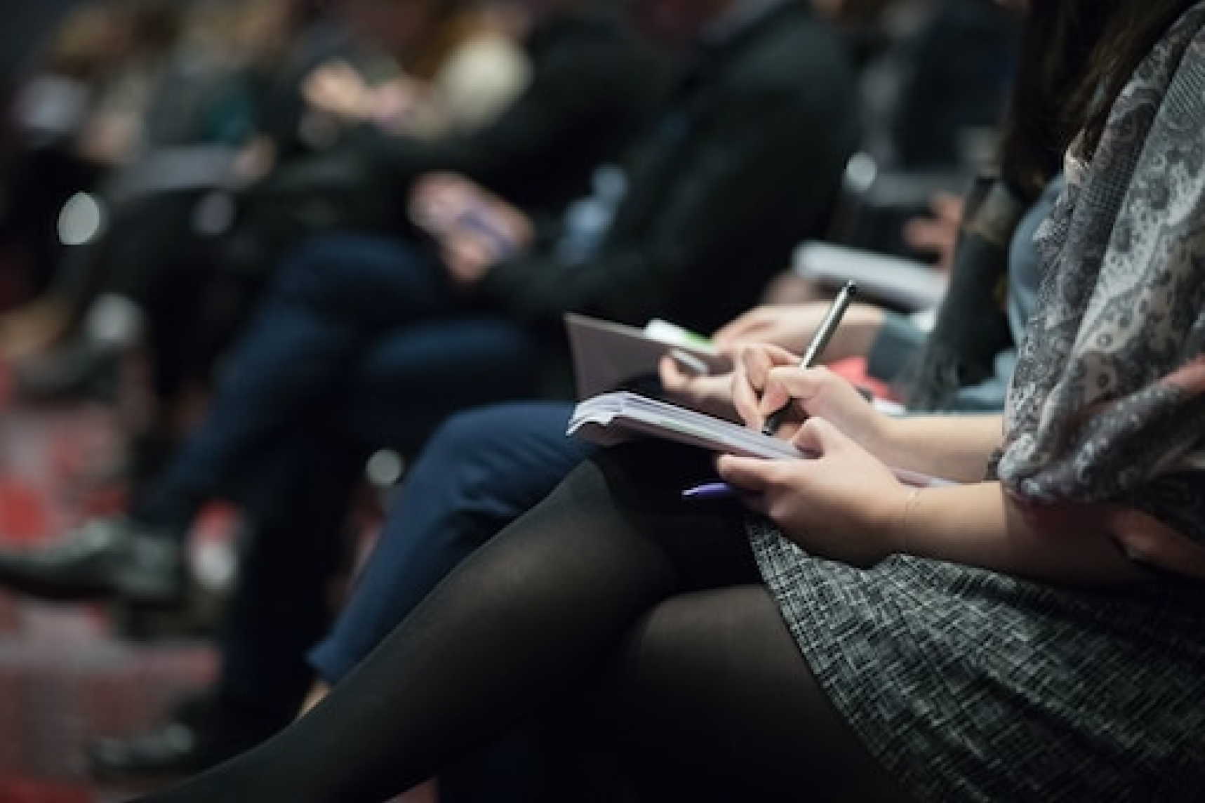 Une personne assise dans une chaise avec un stylo et du papier.