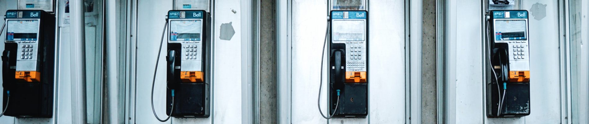 Plusieurs téléphones accrochés au mur.