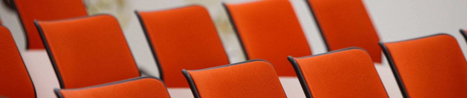 Une rangée de chaises oranges.