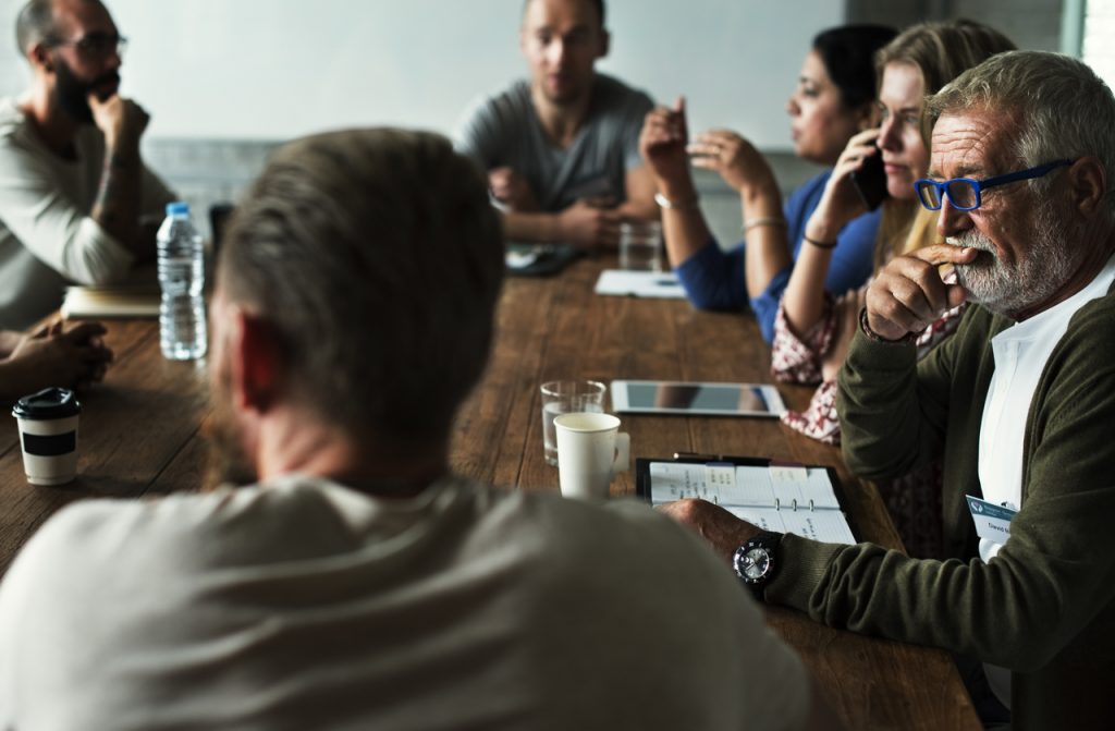 Un groupe de personnes assises autour d'une table.